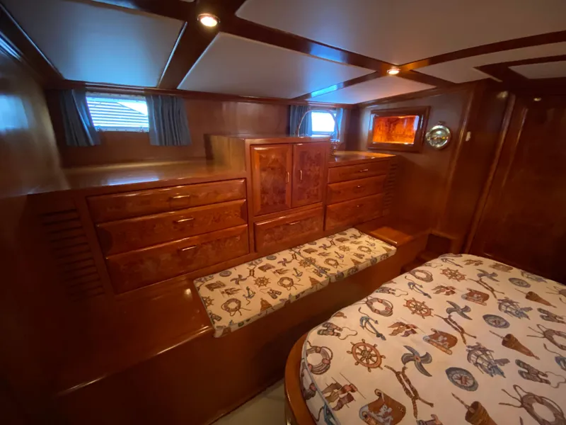 Slide: The Image of Luxurious 1971 Matthews Custom Pilothouse Motor Yacht interior with wooden cabinetry and nautical-themed bedding. - 34