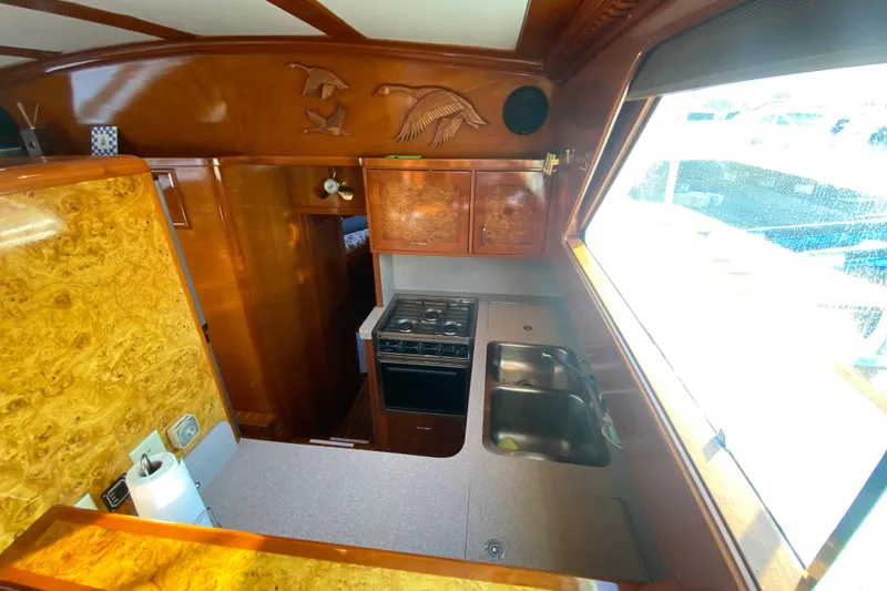 Slide: The Image of 1971 Matthews Custom Pilothouse Motor Yacht kitchen with wood finish and large window. - 35