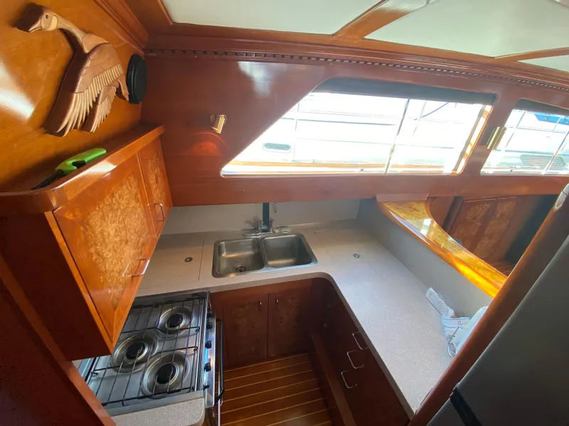 Slide: The Image of 1971 Matthews Custom Pilothouse Motor Yacht kitchen with wood cabinetry and dual sink. - 36