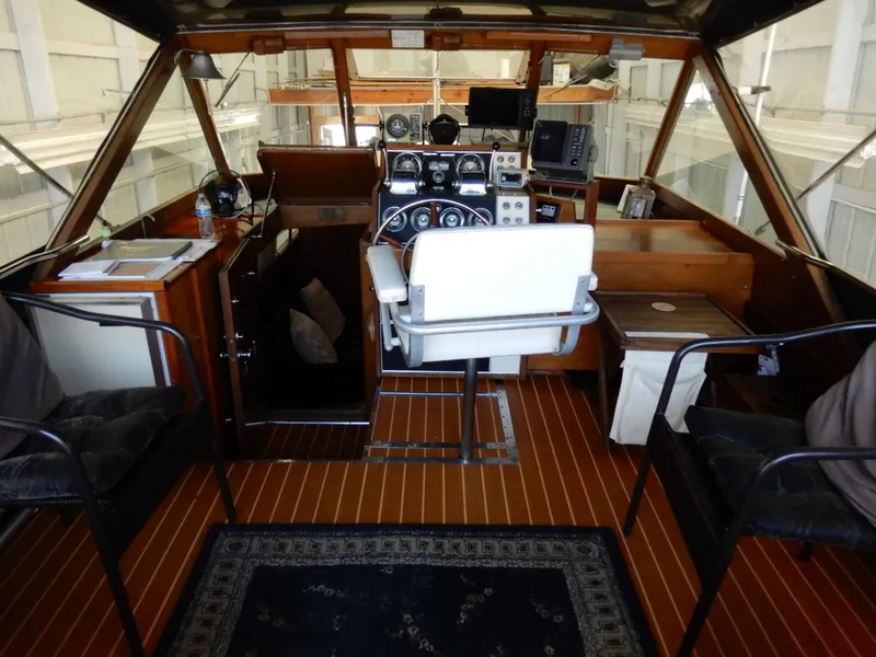 Slide: The Image of 1965 Chris-Craft 38 Constellation boat interior with helm, wooden flooring, and seating. - 5