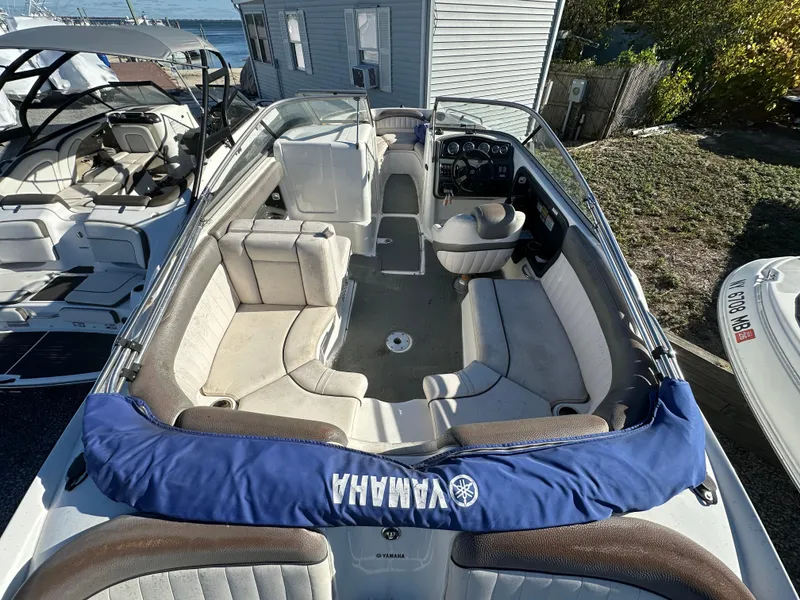 Slide: The Image of 2008 Yamaha Boats SX230 interior with seating and controls, docked near water. - 5