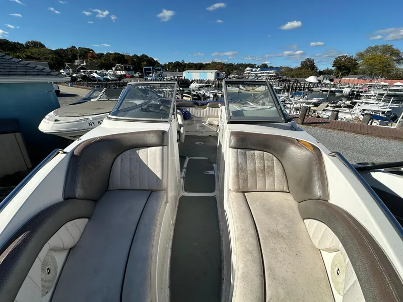 Slide: The Image of 2008 Yamaha Boats SX230 with spacious seating, docked at a marina under a clear blue sky. - 9
