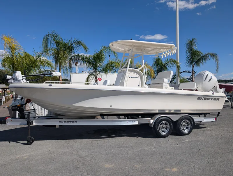 The Image of 2025 Skeeter SX 2550 Family boat on trailer, parked outdoors with palm trees. - 1