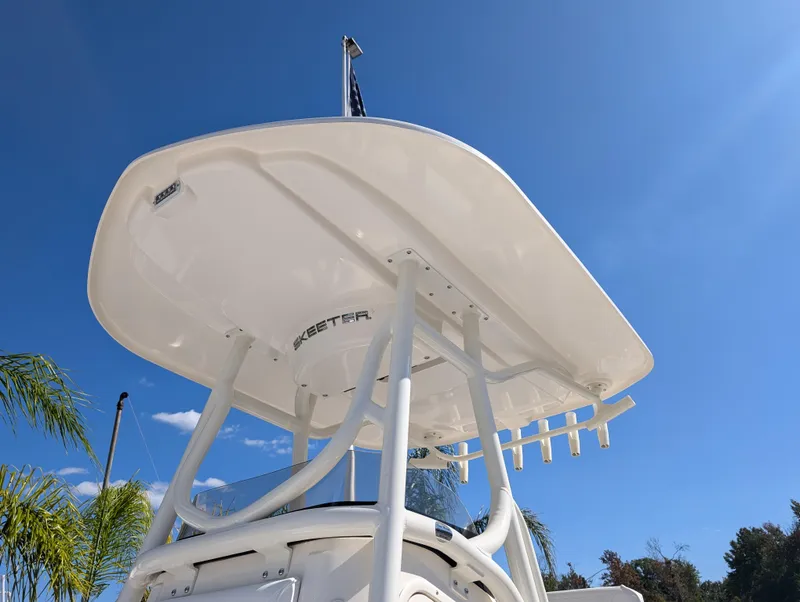 Slide: The Image of 2025 Skeeter SX 2550 Family boat, white T-top against clear blue sky. - 12