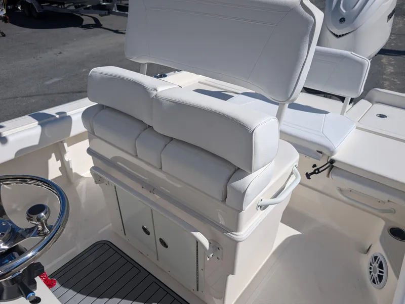 Slide: The Image of 2025 Skeeter SX 2550 Family boat interior with white cushioned seating and steering wheel. - 19