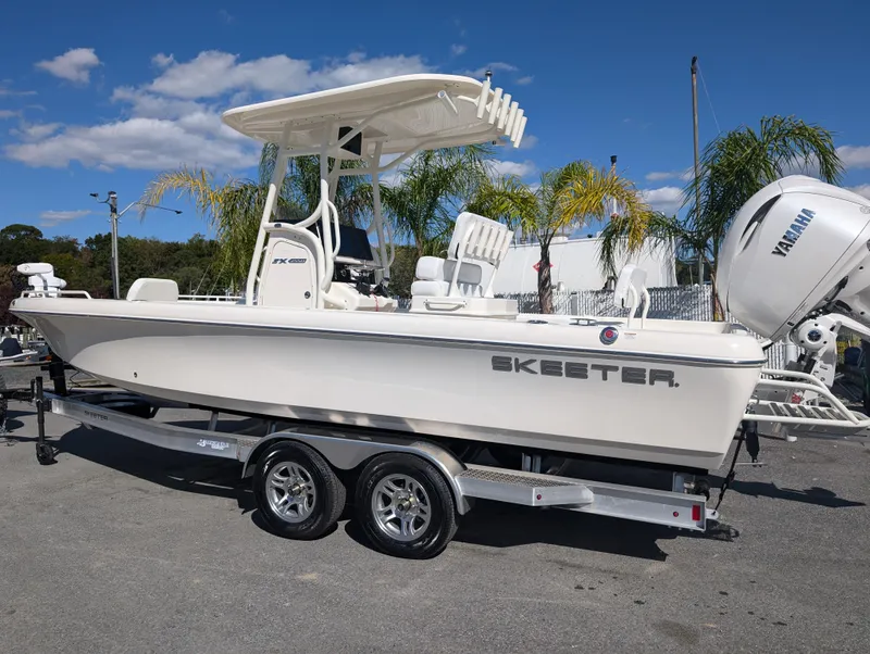 Slide: The Image of 2025 Skeeter SX 2550 Family boat on trailer, sunny day, palm trees in background. - 3