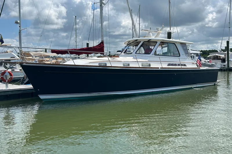 Slide: The Image of 2005 Sabre 42 Hardtop Express yacht docked in a marina under cloudy skies. - 0
