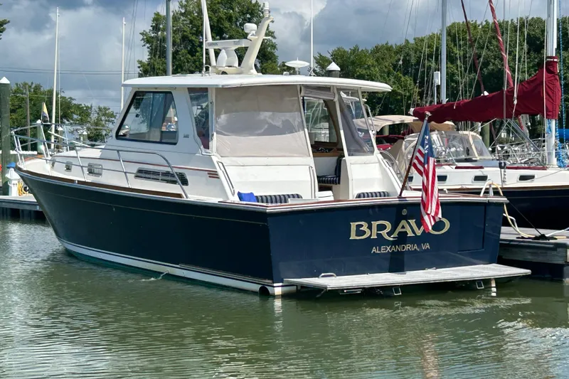 Slide: The Image of 2005 Sabre 42 Hardtop Express boat docked, displaying "Bravo" and American flag. - 2