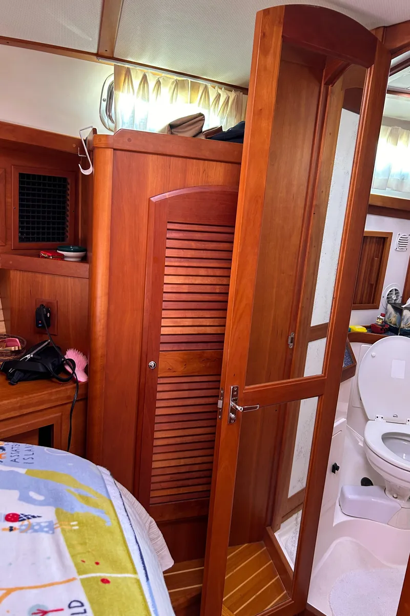 Slide: The Image of 2005 Sabre 42 Hardtop Express cabin interior with wooden finishes and bathroom. - 25