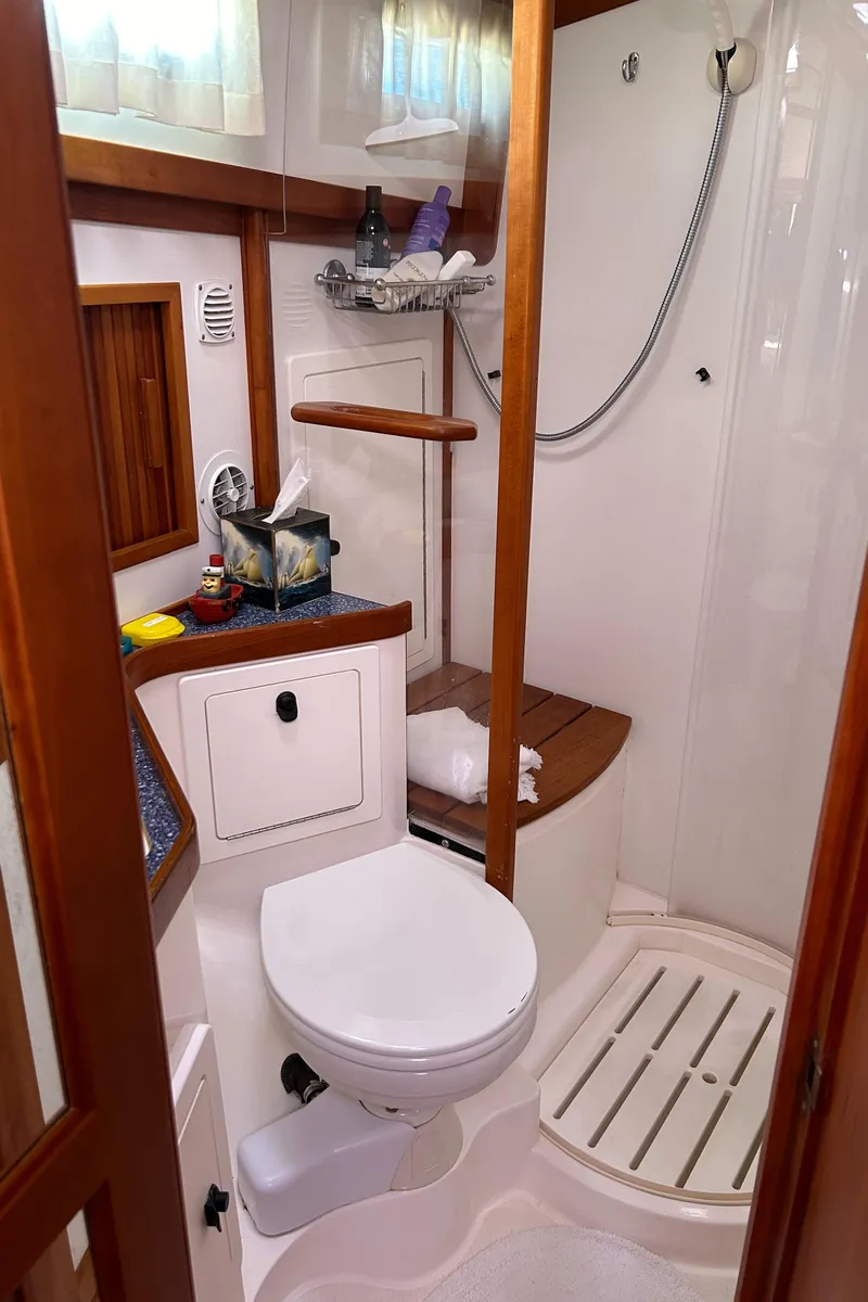 Slide: The Image of 2005 Sabre 42 Hardtop Express bathroom with shower, toilet, and wooden accents. - 27