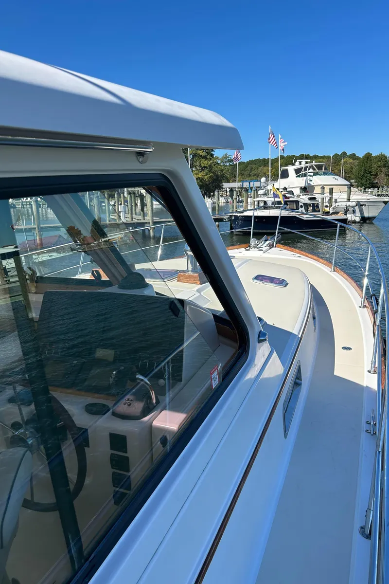 Slide: The Image of 2005 Sabre 42 Hardtop Express yacht docked at marina under clear blue sky. - 39