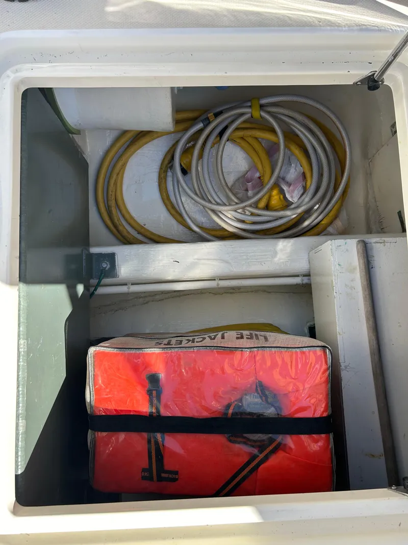 Slide: The Image of Storage compartment on a 2005 Sabre 42 Hardtop Express with coiled cables and a red bag. - 40