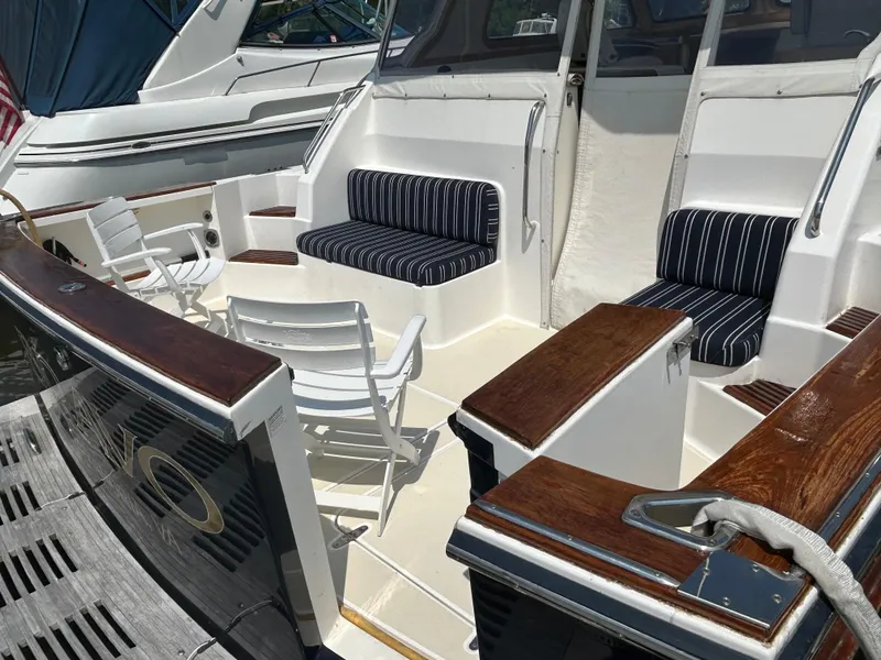 Slide: The Image of 2005 Sabre 42 Hardtop Express yacht with striped seating and white chairs on deck. - 47