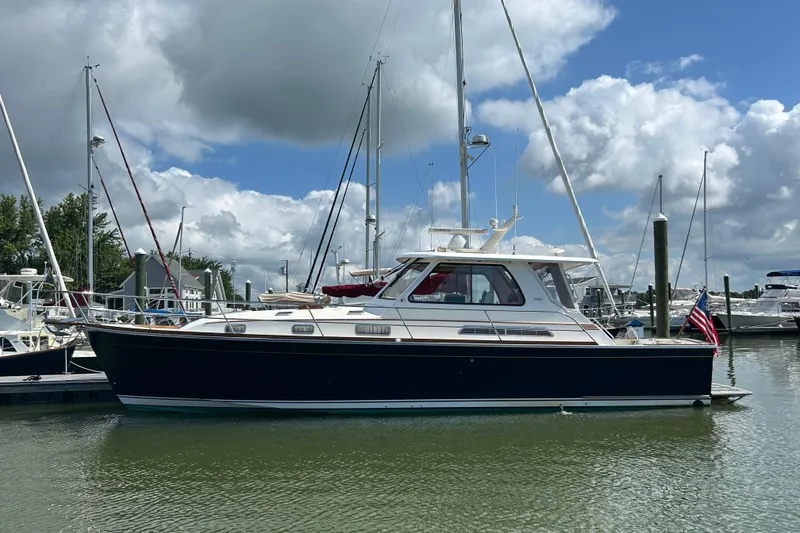 Slide: The Image of 2005 Sabre 42 Hardtop Express yacht docked in a marina under a cloudy sky. - 49
