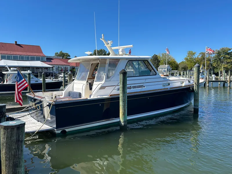 Slide: The Image of 2005 Sabre 42 Hardtop Express yacht docked in a marina, clear blue sky. - 5