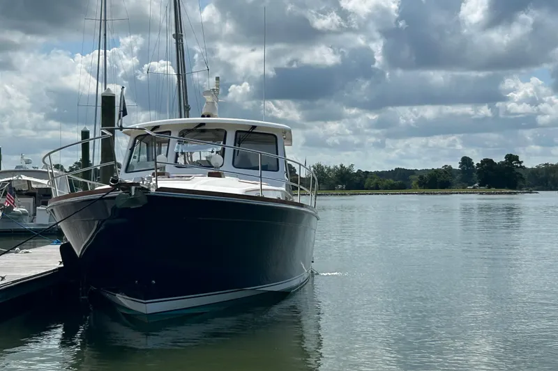Slide: The Image of 2005 Sabre 42 Hardtop Express yacht docked on a calm, scenic waterway. - 50