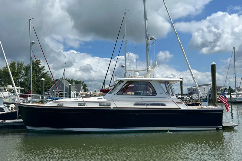 Slide: The Image of 2005 Sabre 42 Hardtop Express yacht docked in a marina under cloudy skies. - 51