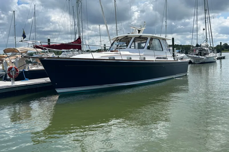 Slide: The Image of 2005 Sabre 42 Hardtop Express yacht docked in a marina under cloudy skies. - 52