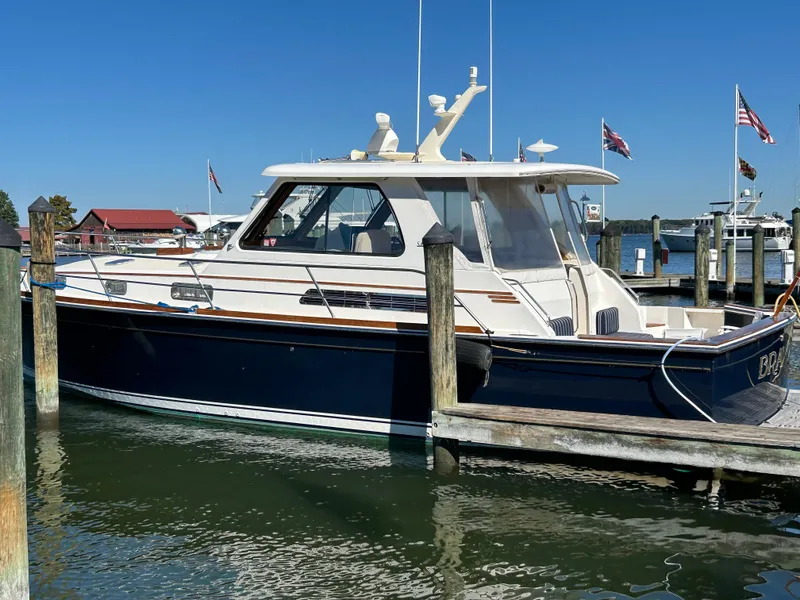Slide: The Image of 2005 Sabre 42 Hardtop Express yacht docked at marina under clear blue sky. - 6