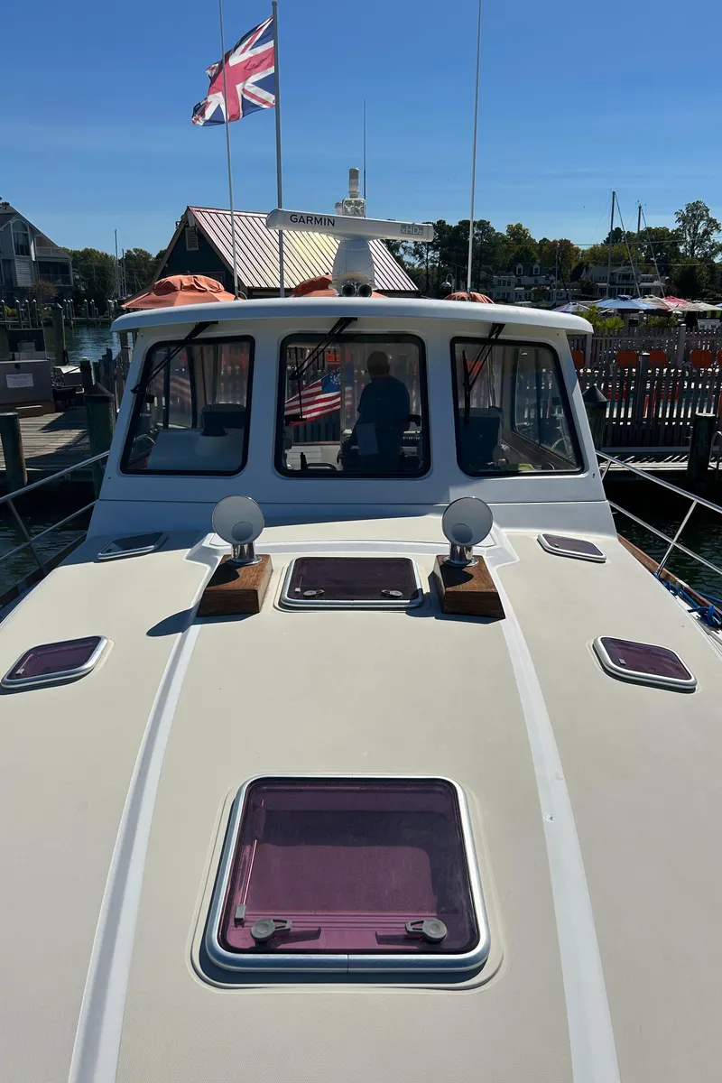 Slide: The Image of 2005 Sabre 42 Hardtop Express yacht docked, featuring a sleek deck and British flag. - 7