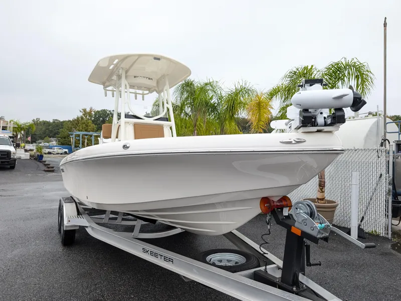 Slide: The Image of 2025 Skeeter SX 2350 boat on trailer, parked outdoors near palm trees. - 2