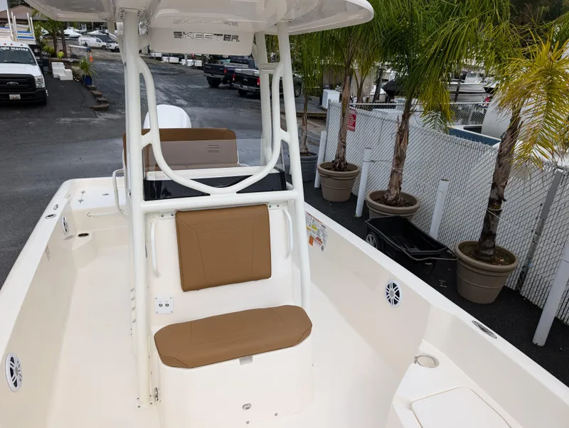 Slide: The Image of 2025 Skeeter SX 2350 boat interior with tan seating, docked near palm trees. - 27