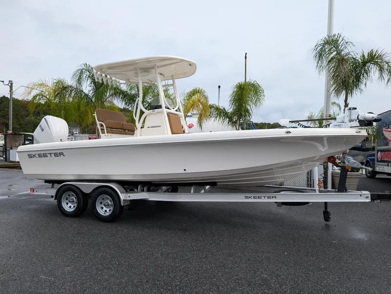 Slide: The Image of 2025 Skeeter SX 2350 boat on trailer, parked near palm trees. - 32