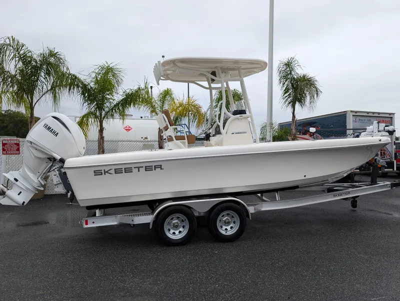 Slide: The Image of 2025 Skeeter SX 2350 boat on trailer, parked outdoors with palm trees in background. - 9