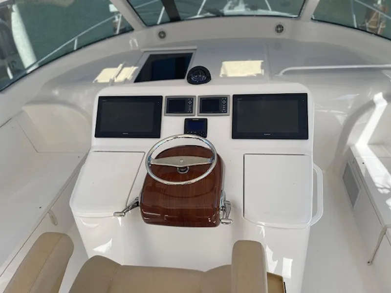Slide: The Image of 2012 Viking 42 Open helm with dual screens and wooden steering wheel. - 13