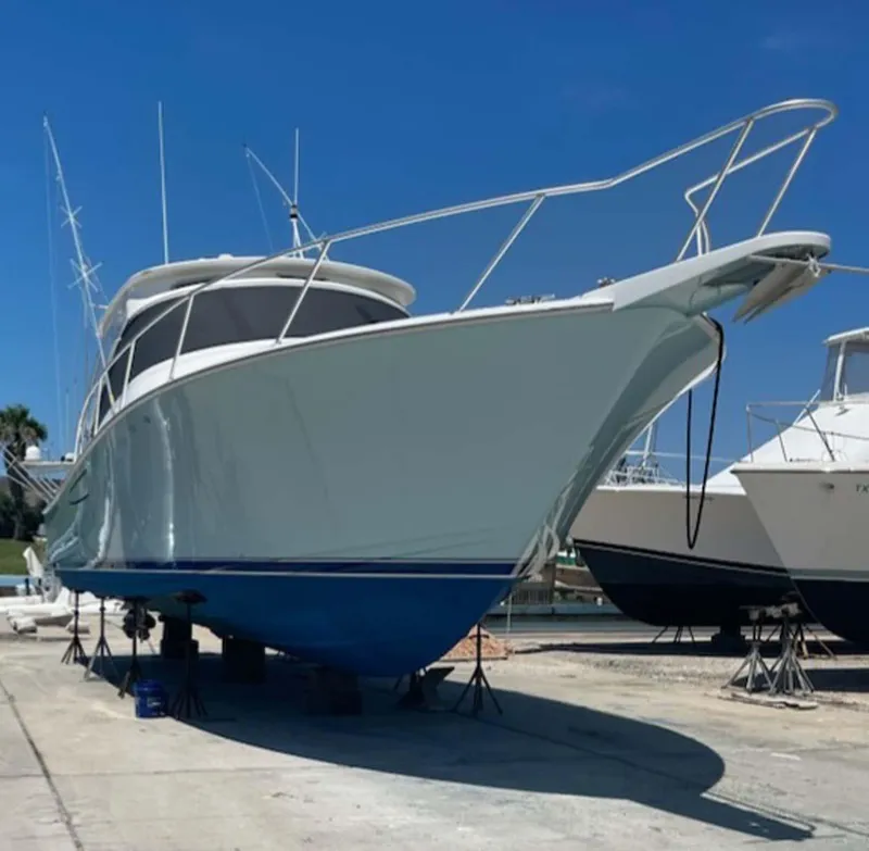 Slide: The Image of 2012 Viking 42 Open yacht on dry dock under clear blue sky. - 3
