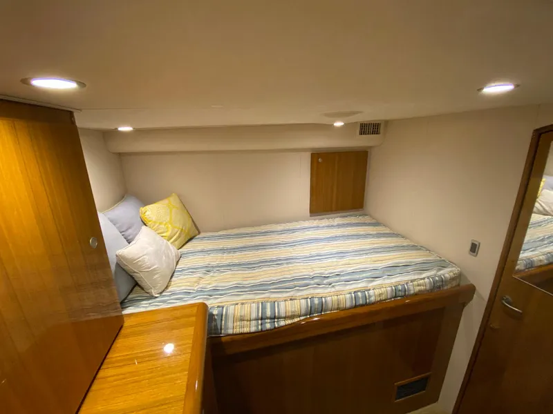 Slide: The Image of 2012 Viking 42 Open cabin with cozy bed and wooden furnishings. - 7