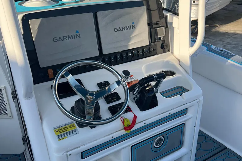 Slide: The Image of 2020 Sea Hunt Gamefish 25 dashboard with Garmin displays and steering wheel. - 19