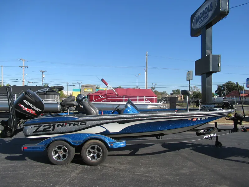 Slide: The Image of 2016 Nitro Z21 boat with trailer, parked outdoors under clear blue sky. - 7