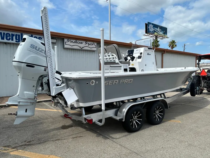 Slide: The Image of 2025 Sea Pro 230 Bay boat on trailer, parked outdoors near a university building. - 5