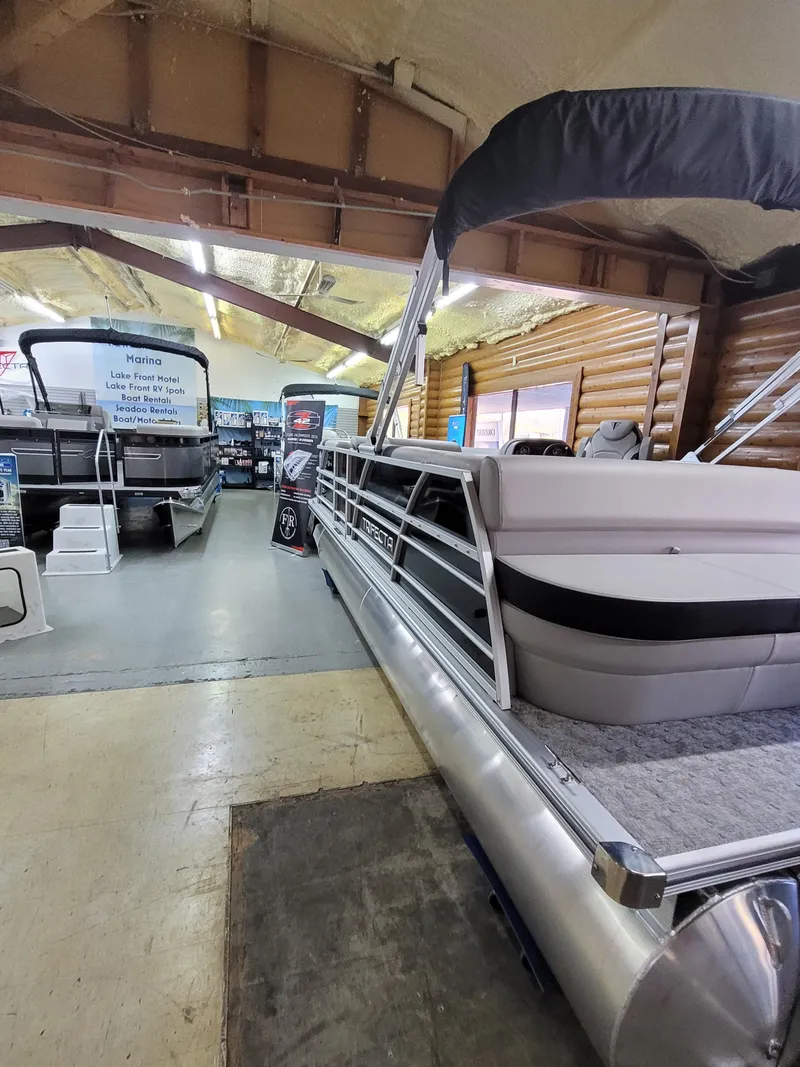 Slide: The Image of 2025 Trifecta 22TRC2LE275 pontoon boat displayed in showroom. - 2