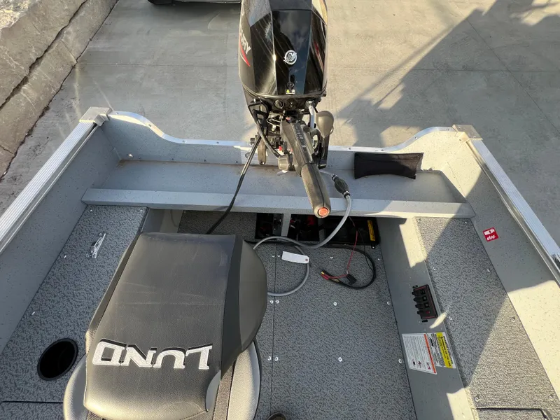 Slide: The Image of 2025 Lund 1600 Fury Tiller boat interior with motor and seating. - 10