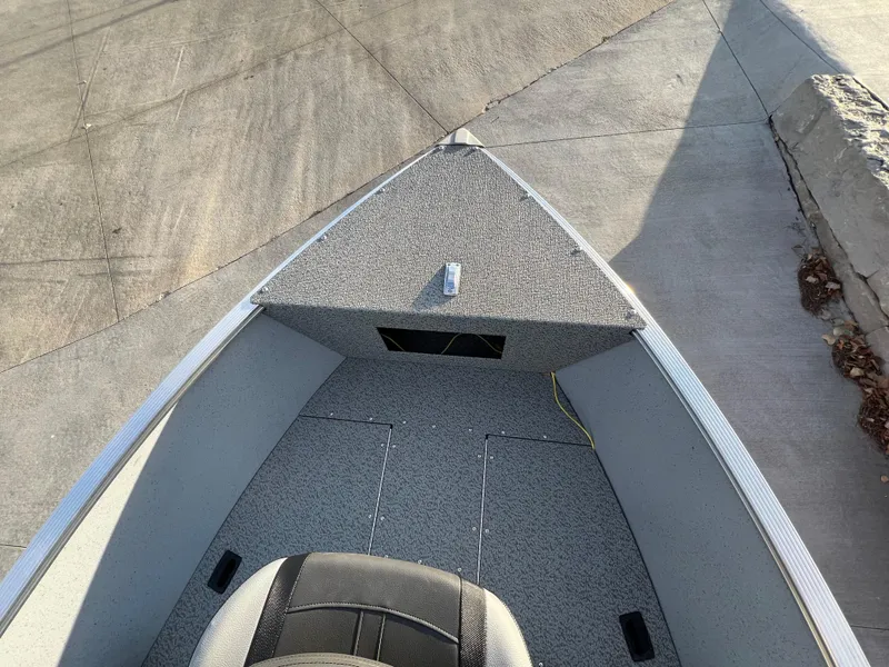 Slide: The Image of 2025 Lund 1600 Fury Tiller boat interior, featuring a spacious, carpeted deck and seating. - 12