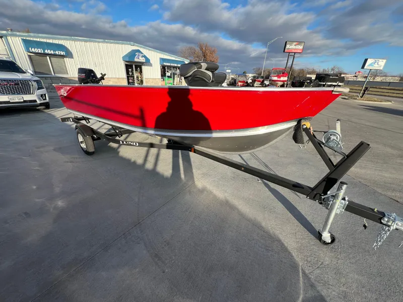 Slide: The Image of 2025 Lund 1600 Fury Tiller boat in vibrant red on a trailer, outdoor dealership setting. - 5