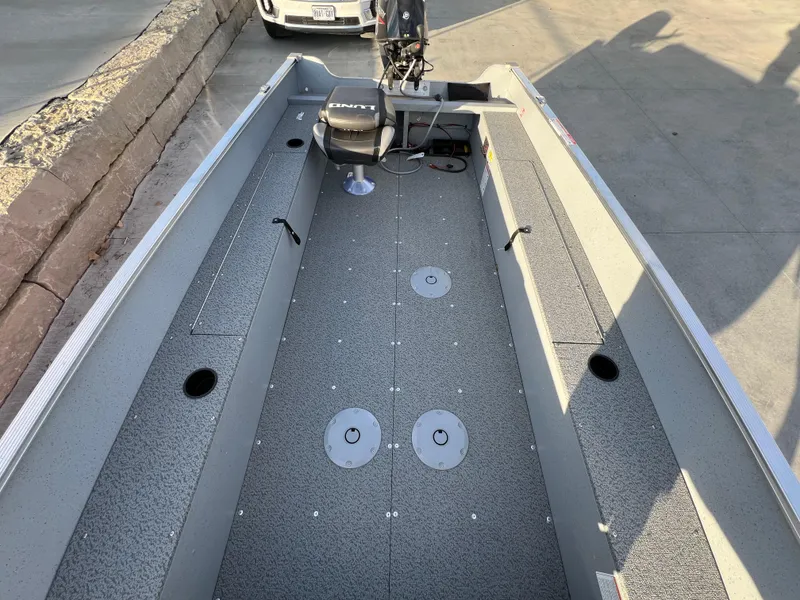 Slide: The Image of 2025 Lund 1600 Fury Tiller boat interior with gray flooring and seating. - 6