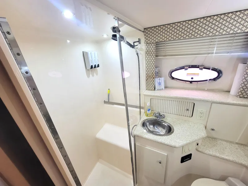 Slide: The Image of 1999 Carver 356 Aft Cabin Motor Yacht bathroom with shower, sink, and porthole window. - 10