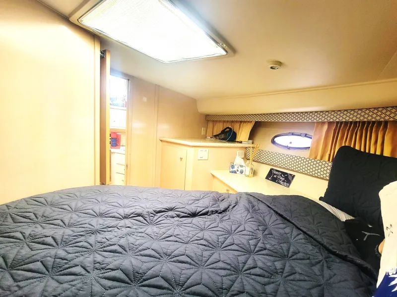 Slide: The Image of Interior of 1999 Carver 356 Aft Cabin Motor Yacht with cozy bedroom setup. - 11