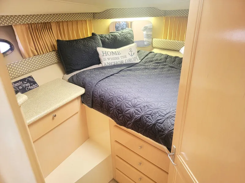 Slide: The Image of Cozy bedroom in 1999 Carver 356 Aft Cabin Motor Yacht with quilted bedding. - 12