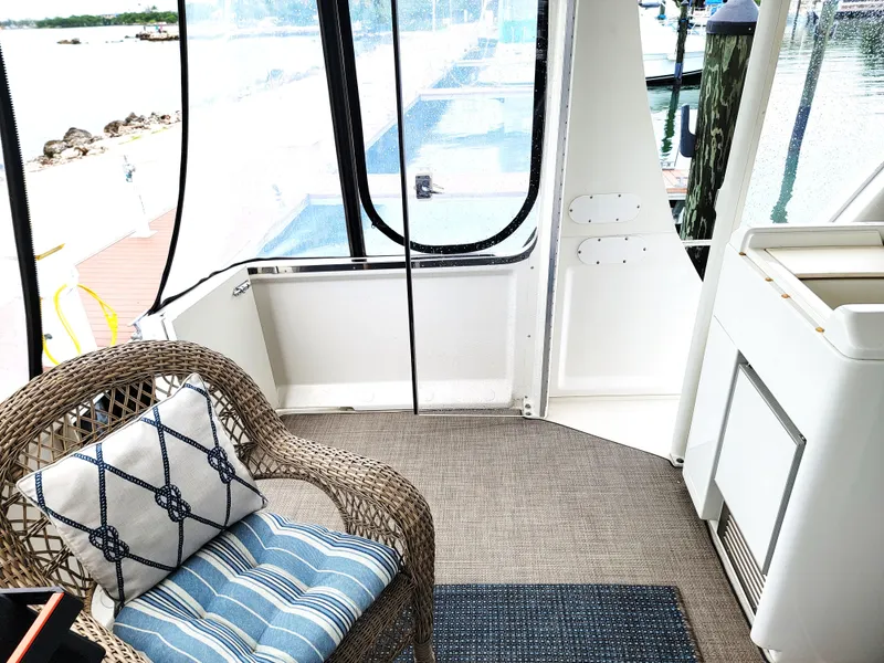 Slide: The Image of 1999 Carver 356 Aft Cabin Motor Yacht interior with wicker chair and nautical decor. - 19
