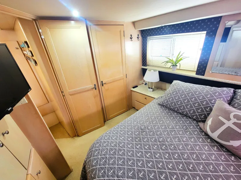 Slide: The Image of Cozy bedroom in 1999 Carver 356 Aft Cabin Motor Yacht with nautical decor. - 6