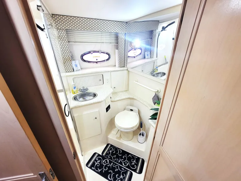 Slide: The Image of 1999 Carver 356 Aft Cabin Motor Yacht bathroom with sink, toilet, and porthole windows. - 9