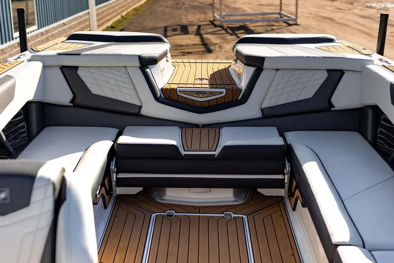 Slide: The Image of 2022 Nautique Super Air Nautique G25 interior with luxurious seating and teak flooring. - 12