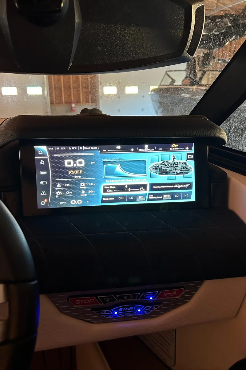 Slide: The Image of 2022 Nautique Super Air Nautique G25 dashboard with digital display in a boat interior. - 16