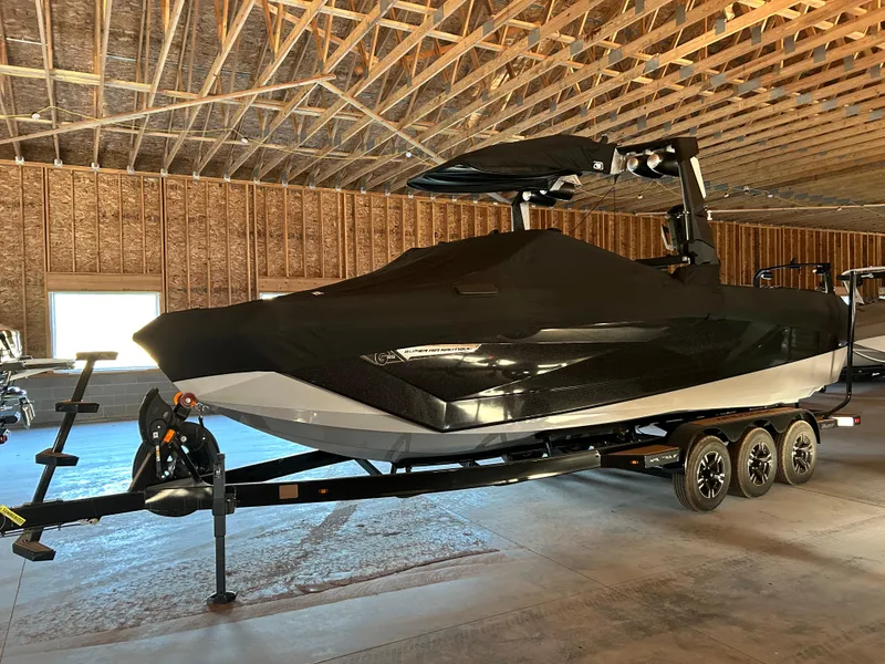 Slide: The Image of 2022 Nautique Super Air Nautique G25 boat on trailer in a wooden garage. - 2