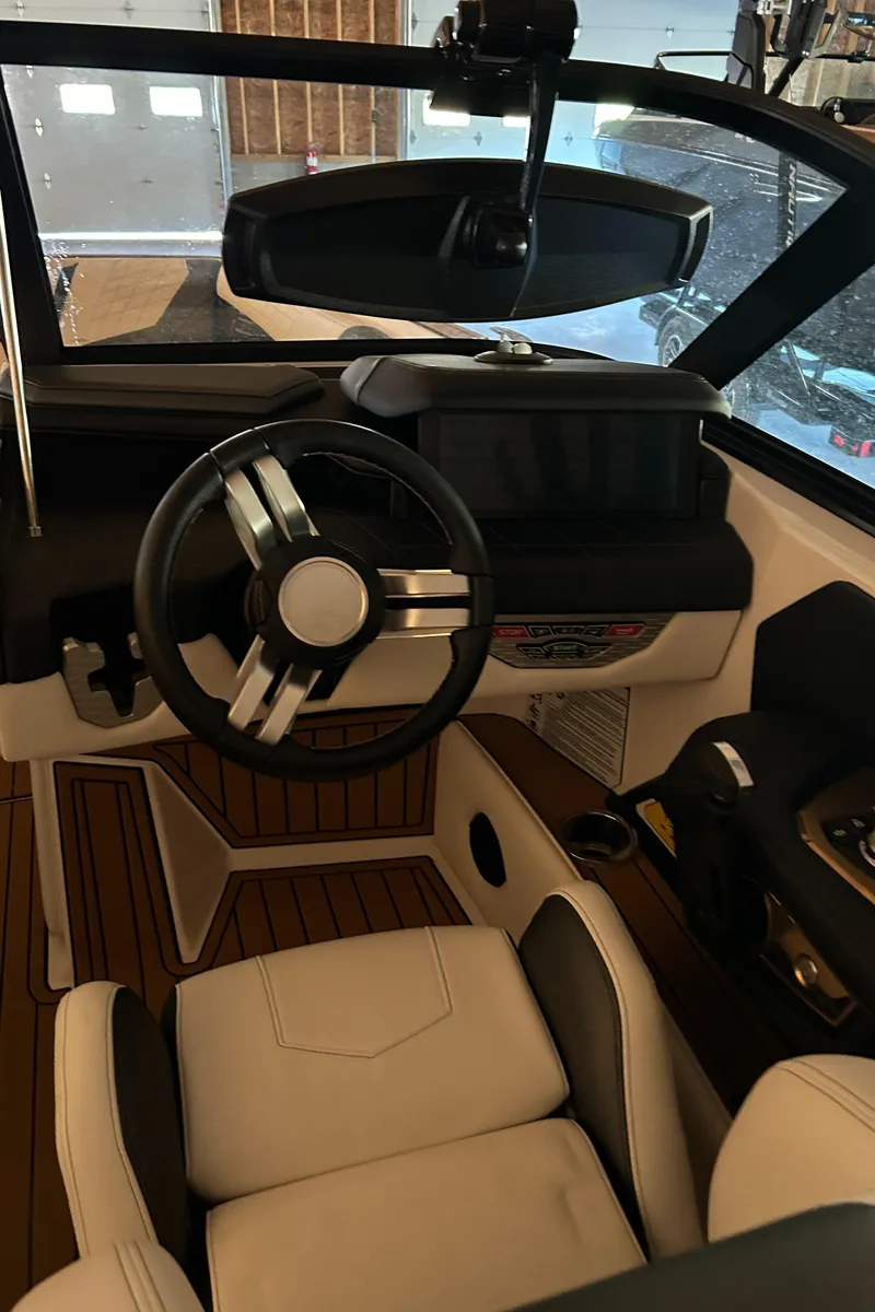 Slide: The Image of Interior of 2022 Nautique Super Air Nautique G25 boat with modern steering wheel. - 21