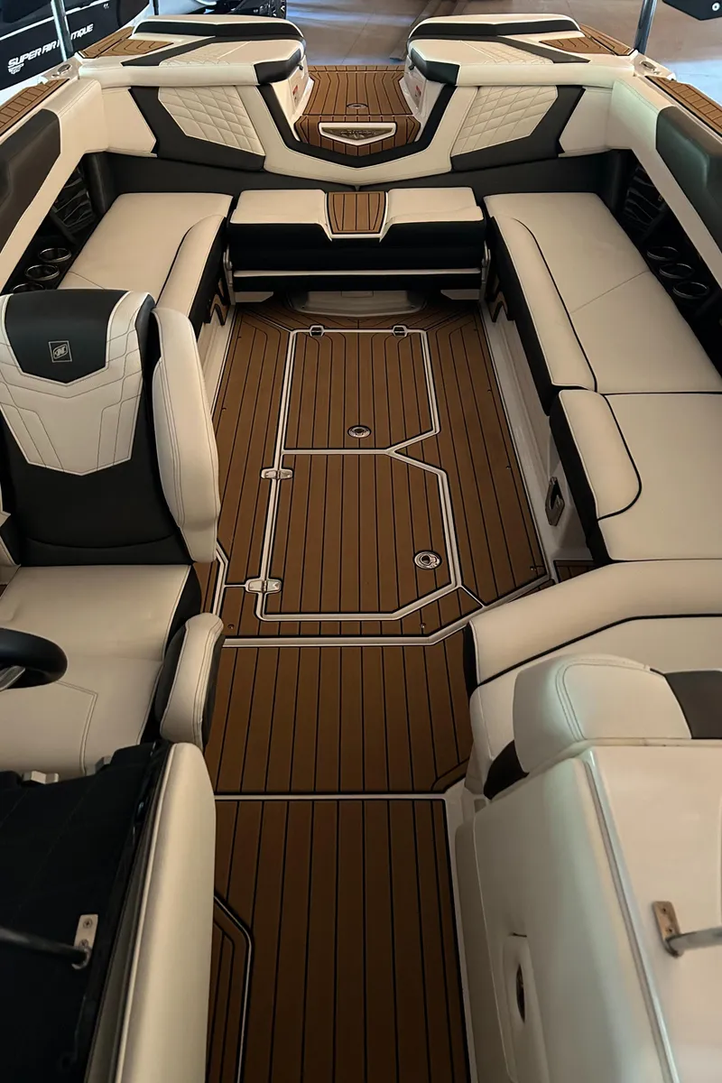 Slide: The Image of 2022 Nautique Super Air Nautique G25 interior with luxurious seating and teak flooring. - 22
